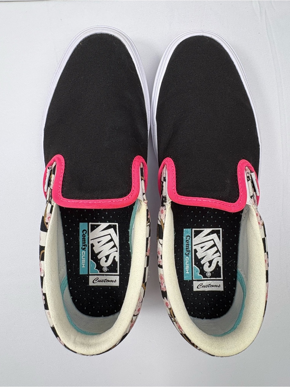 Vans Classic Slip-Ons with a Unique Black Canvas Upper & Floral Pattern on Heel.